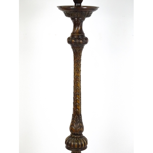 1555 - A mahogany carved and turned column standard lamp with triform base having scroll and paw feet. Appr... 