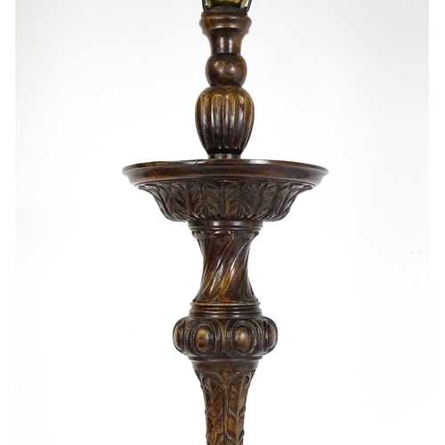 1555 - A mahogany carved and turned column standard lamp with triform base having scroll and paw feet. Appr... 