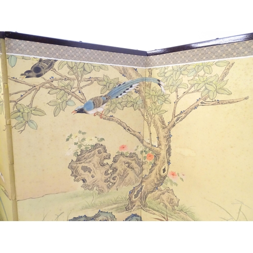 1661 - A mid 20thC Oriental folding screen, the four sections decorated with red-billed blue magpies, crest... 