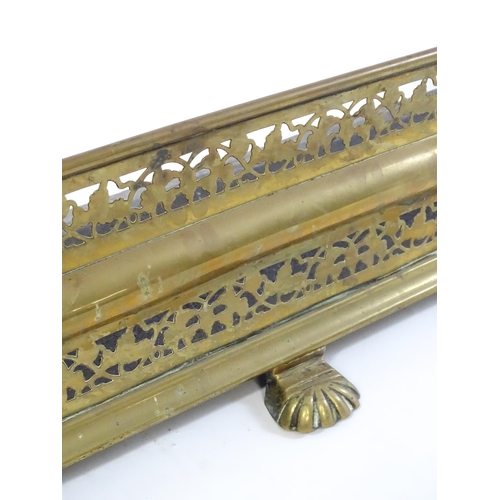 1745 - A late 19thC brass fire fender with pierced decoration and raised on lions paw style feet. 44