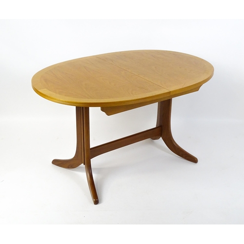 1750 - A G-Plan style teak extending dining table, the oval top supported by a pedestal base standing on fo... 