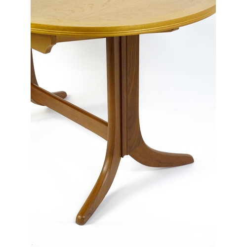 1750 - A G-Plan style teak extending dining table, the oval top supported by a pedestal base standing on fo... 