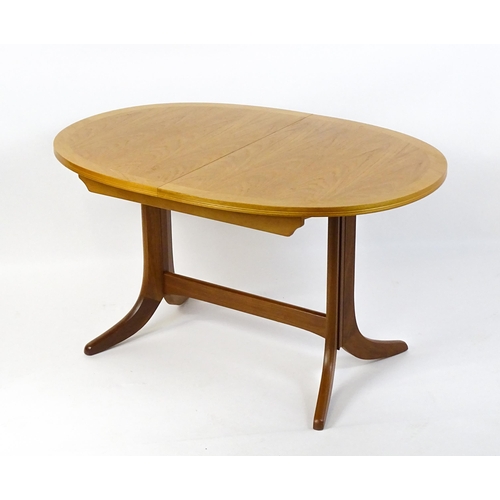 1750 - A G-Plan style teak extending dining table, the oval top supported by a pedestal base standing on fo... 