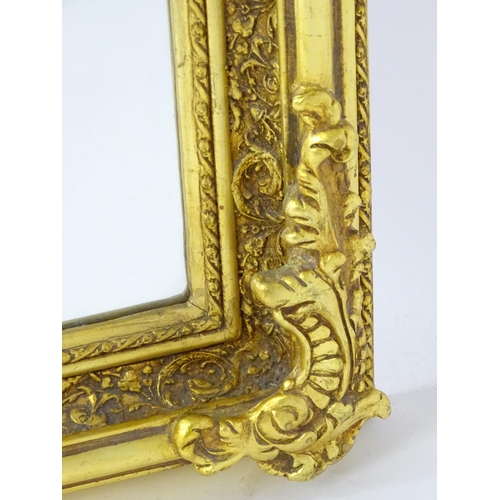 1701 - A modern mirror with a gilt and gesso frame surrounded by floral mouldings. 34