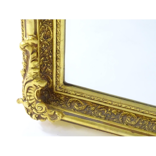 1701 - A modern mirror with a gilt and gesso frame surrounded by floral mouldings. 34