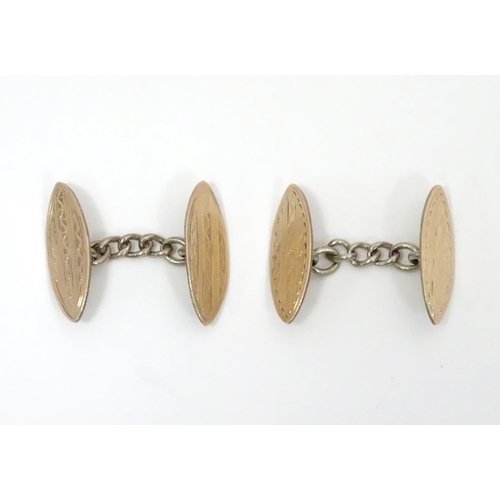 700 - A pair of white metal cufflinks with engraved decoration