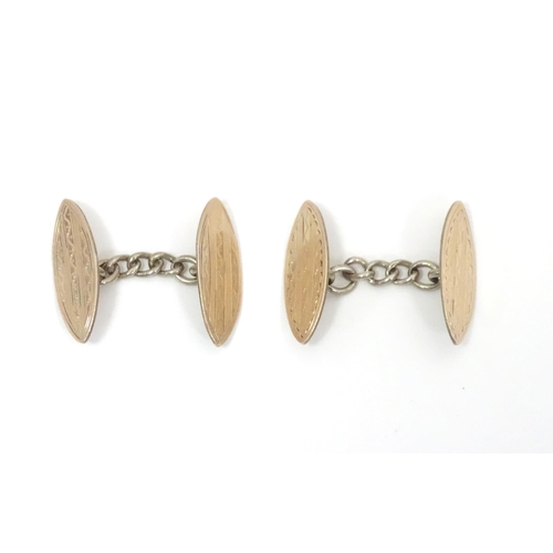 700 - A pair of white metal cufflinks with engraved decoration