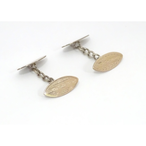 700 - A pair of white metal cufflinks with engraved decoration