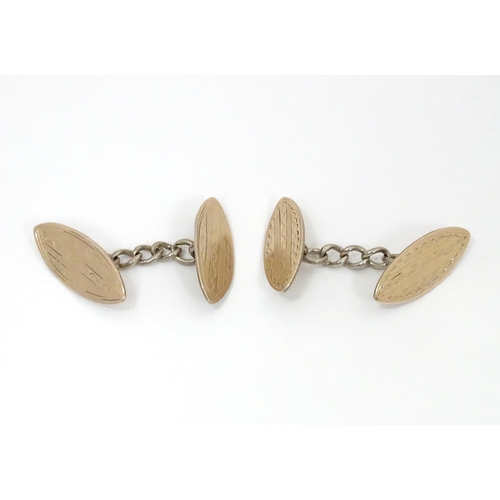 700 - A pair of white metal cufflinks with engraved decoration