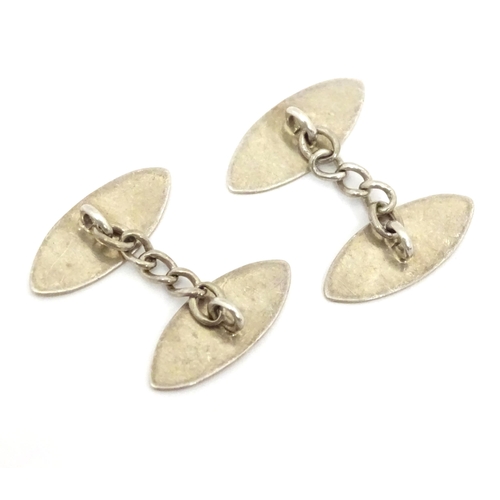 700 - A pair of white metal cufflinks with engraved decoration