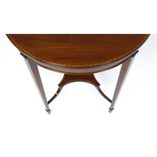 1653 - An Edwardian mahogany side table with a circular crossbanded top above a shaped under tier raised on... 