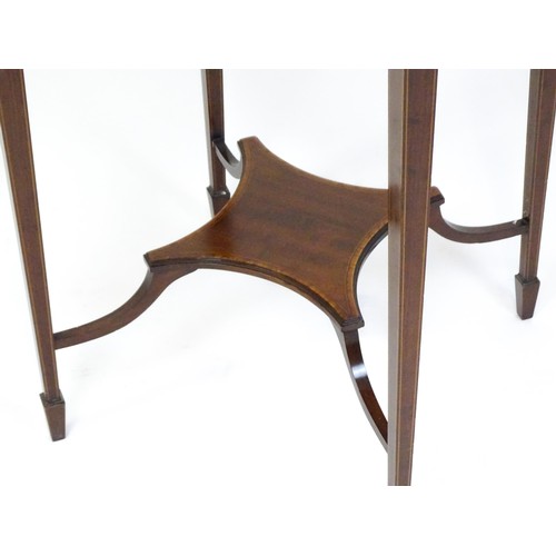 1653 - An Edwardian mahogany side table with a circular crossbanded top above a shaped under tier raised on... 