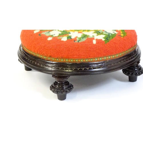 13 - Two early 20thC footstools with needlework upholstered tops and each raised on four short feet. The ... 