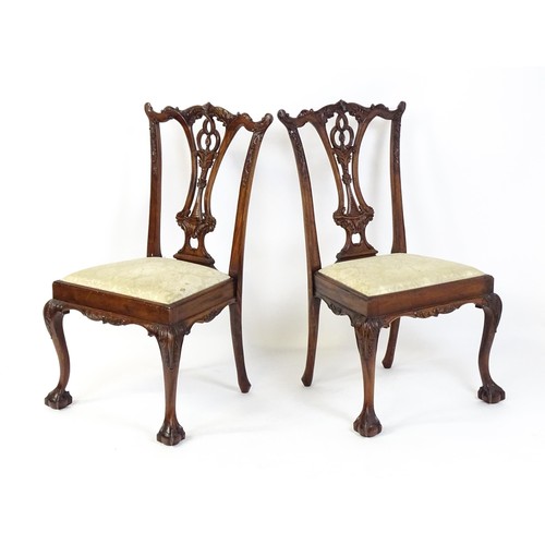 21 - A pair of late 20thC mahogany Chippendale style chairs with acanthus carved frames and raised on car... 