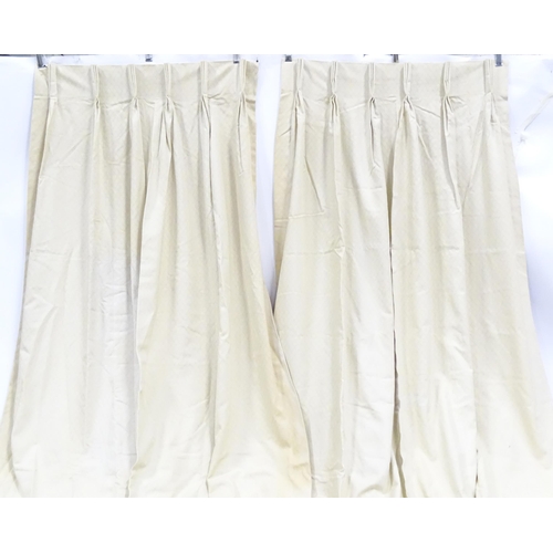 99 - A pair of curtains with a cream ground with lozenge detail. Approx. 45