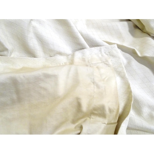 99 - A pair of curtains with a cream ground with lozenge detail. Approx. 45