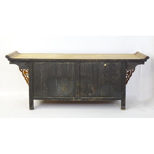 315 - A mid 20thC oriental sideboard with a planked top, shaped ends and pierced brackets to either side w... 