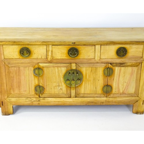 315 - A mid 20thC oriental sideboard with a planked top, shaped ends and pierced brackets to either side w... 
