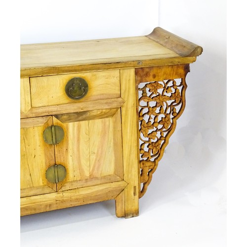 315 - A mid 20thC oriental sideboard with a planked top, shaped ends and pierced brackets to either side w... 