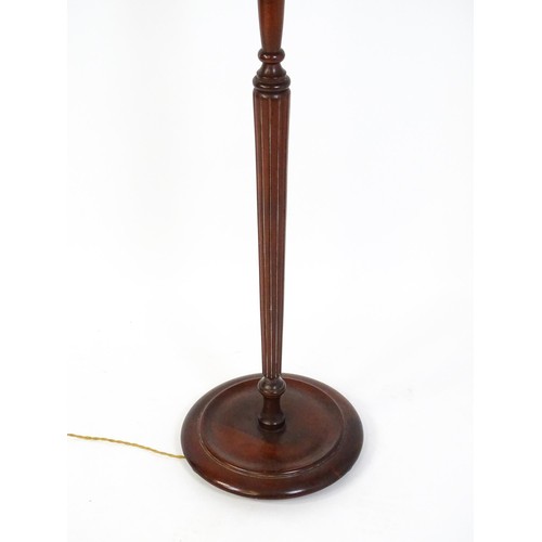 322 - A mahogany standard lamp with a turned tapering stem and circular base. 70