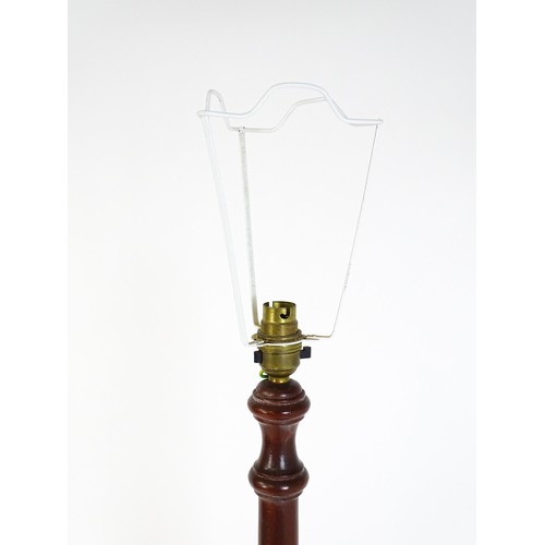 322 - A mahogany standard lamp with a turned tapering stem and circular base. 70