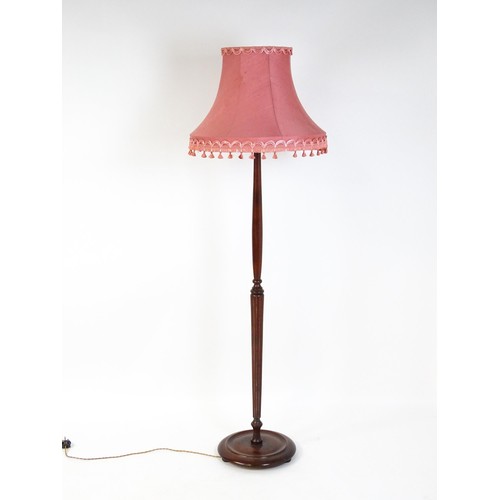 322 - A mahogany standard lamp with a turned tapering stem and circular base. 70