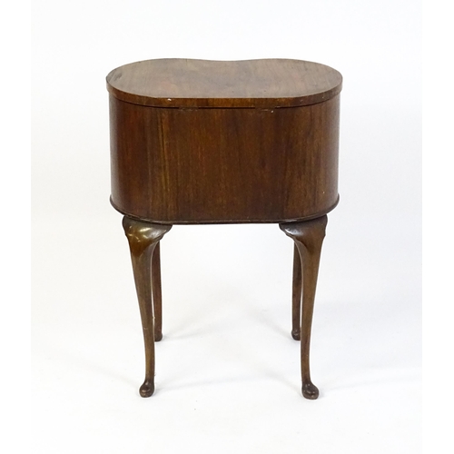 328 - An early / mid 20thC walnut work box of kidney form, having a hinged lid, fabric lined interior and ... 