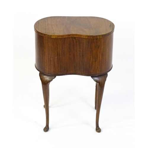 328 - An early / mid 20thC walnut work box of kidney form, having a hinged lid, fabric lined interior and ... 