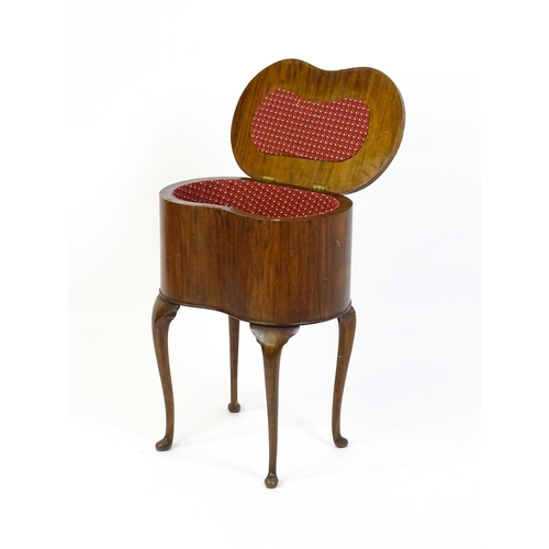 328 - An early / mid 20thC walnut work box of kidney form, having a hinged lid, fabric lined interior and ... 