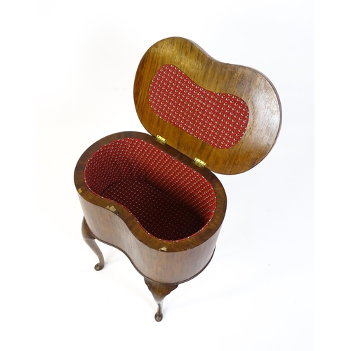 328 - An early / mid 20thC walnut work box of kidney form, having a hinged lid, fabric lined interior and ... 