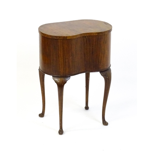 328 - An early / mid 20thC walnut work box of kidney form, having a hinged lid, fabric lined interior and ... 
