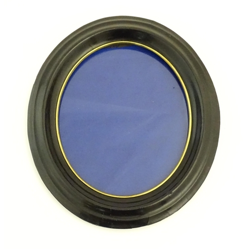 329 - A pair of early 20thC ebonised frames of oval form. Together with a ebonised frame of circular form.... 