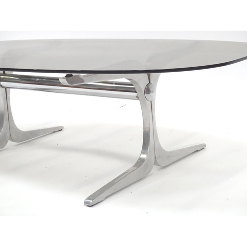 331 - A 20thC coffee table, with elliptical smoky glass top supported by a brushed aluminium frame. In the... 