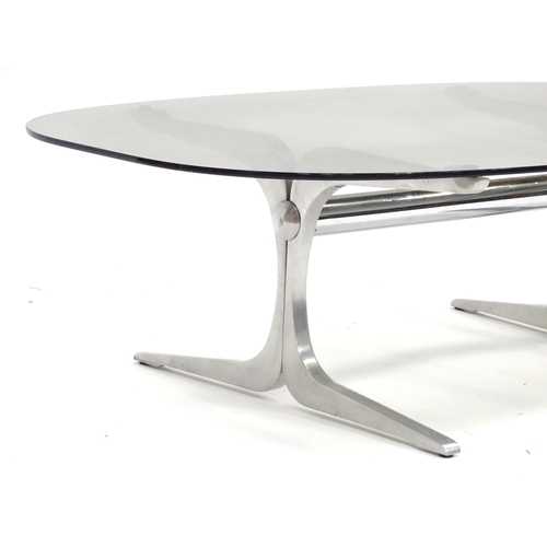 331 - A 20thC coffee table, with elliptical smoky glass top supported by a brushed aluminium frame. In the... 