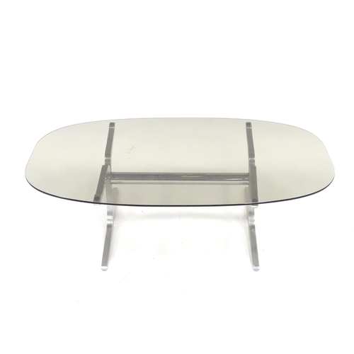 331 - A 20thC coffee table, with elliptical smoky glass top supported by a brushed aluminium frame. In the... 