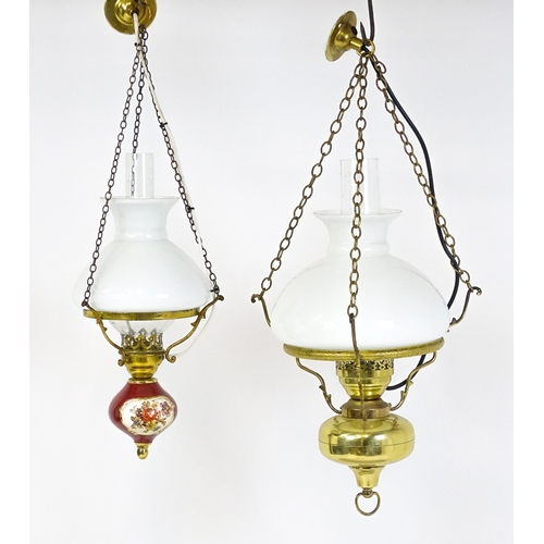 349 - Two pendant oil lamps one with ceramic reservoir with floral detail. Largest approx. 11