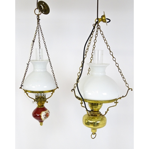 349 - Two pendant oil lamps one with ceramic reservoir with floral detail. Largest approx. 11