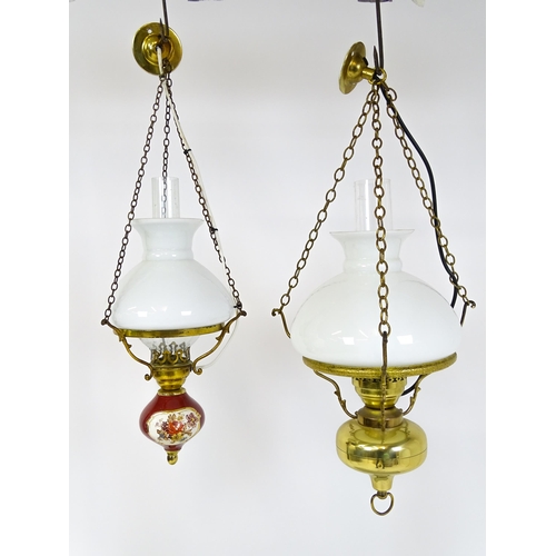 349 - Two pendant oil lamps one with ceramic reservoir with floral detail. Largest approx. 11