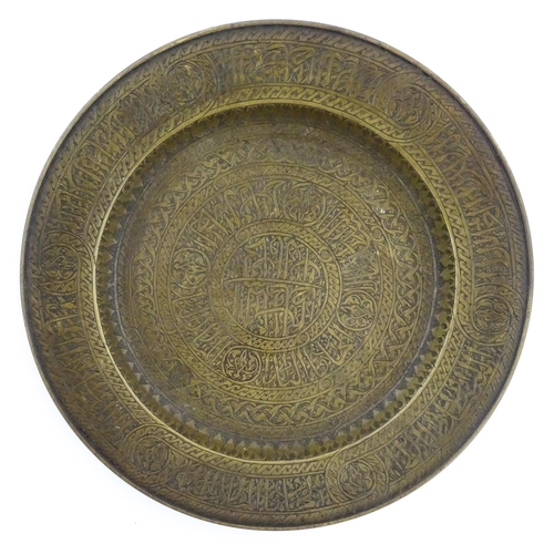 370 - A Middle Eastern brass dish with script and banded detail. Approx. 9 1/2