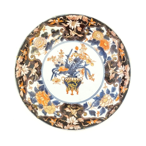 411 - A Japanese plate decorated in the Imari palette decorated with flowers and foliage, with further flo... 
