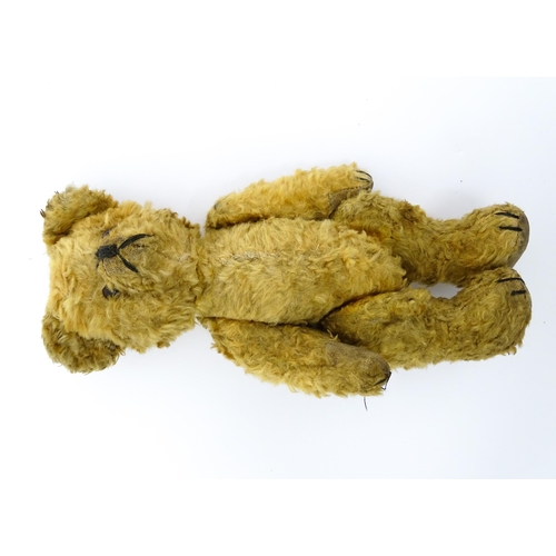 412 - Toy: An early 20thC teddy bear with stitched nose and mouth and articulated limbs. Approx. 9 1/4
