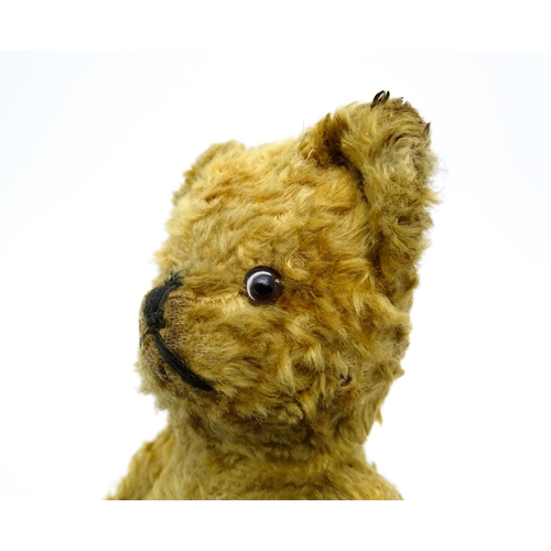 412 - Toy: An early 20thC teddy bear with stitched nose and mouth and articulated limbs. Approx. 9 1/4
