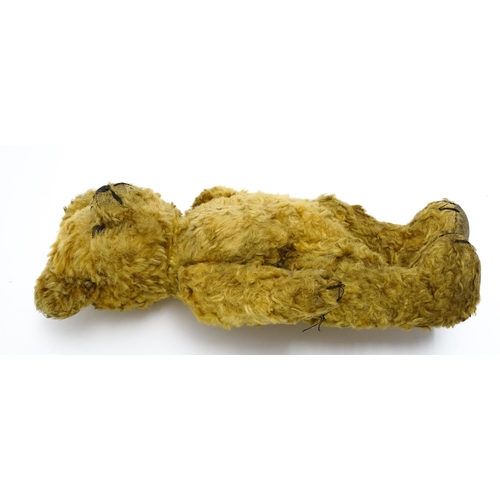 412 - Toy: An early 20thC teddy bear with stitched nose and mouth and articulated limbs. Approx. 9 1/4