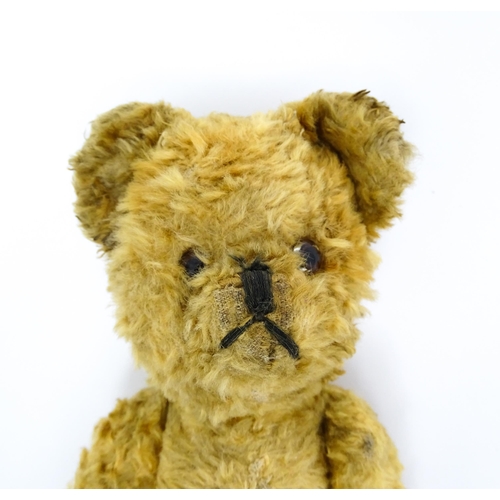 412 - Toy: An early 20thC teddy bear with stitched nose and mouth and articulated limbs. Approx. 9 1/4