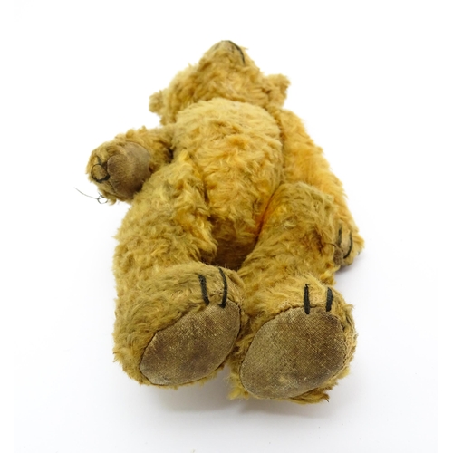 412 - Toy: An early 20thC teddy bear with stitched nose and mouth and articulated limbs. Approx. 9 1/4
