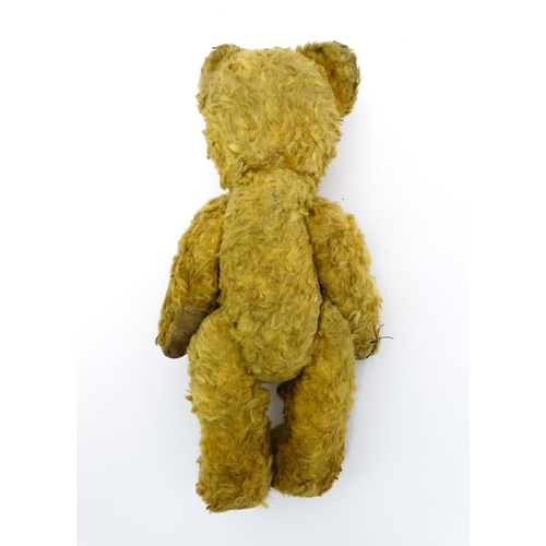 412 - Toy: An early 20thC teddy bear with stitched nose and mouth and articulated limbs. Approx. 9 1/4