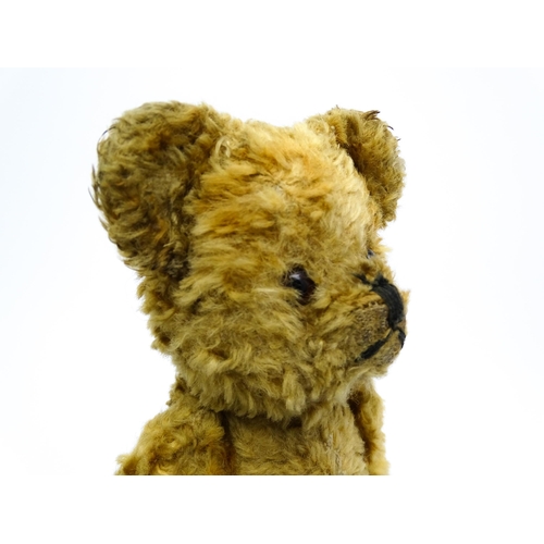 412 - Toy: An early 20thC teddy bear with stitched nose and mouth and articulated limbs. Approx. 9 1/4