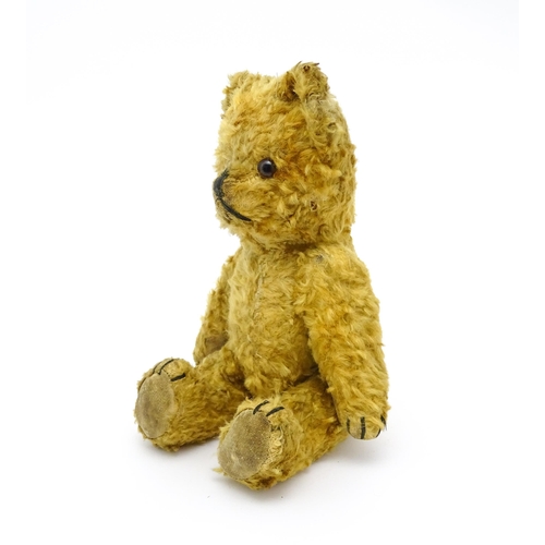 412 - Toy: An early 20thC teddy bear with stitched nose and mouth and articulated limbs. Approx. 9 1/4