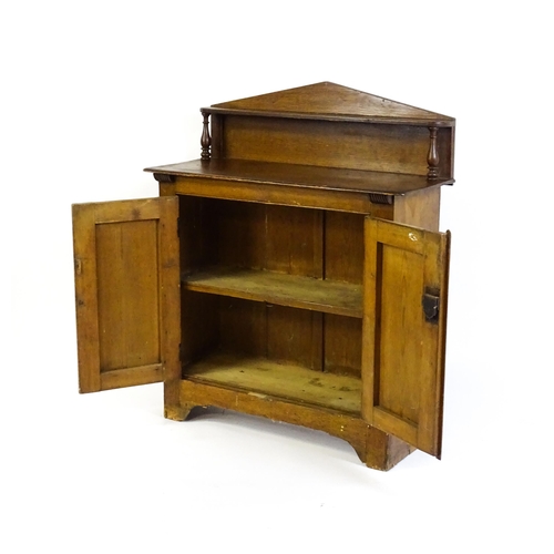 611 - A 19thC simulated oak chiffonier with a pointed upstand above turned supports and two panelled doors... 