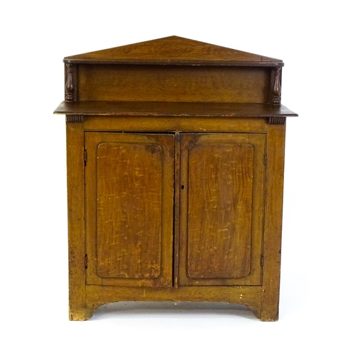 611 - A 19thC simulated oak chiffonier with a pointed upstand above turned supports and two panelled doors... 